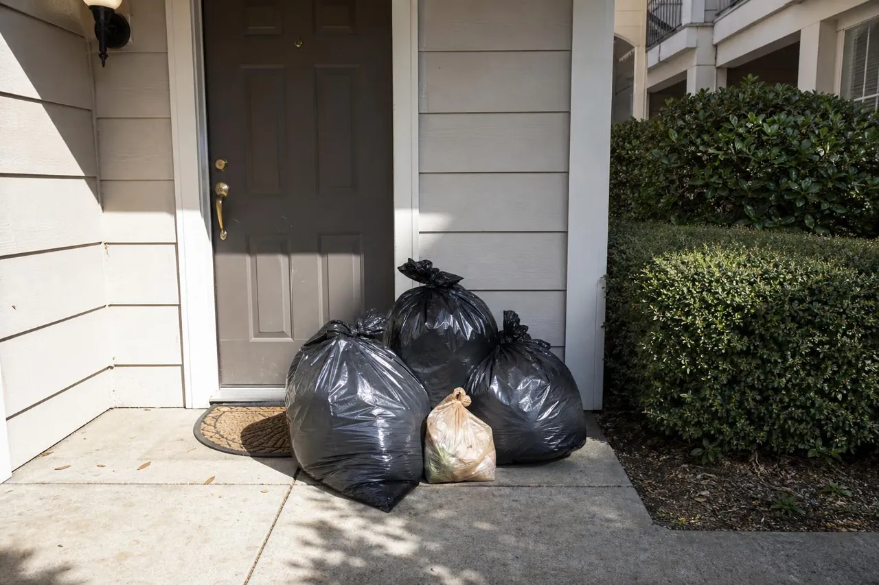 Overflowing apartment dumpster enclosure with scattered trash bags before Roze Green valet service